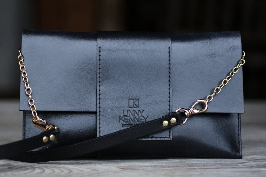Gold chain and black leather clutch